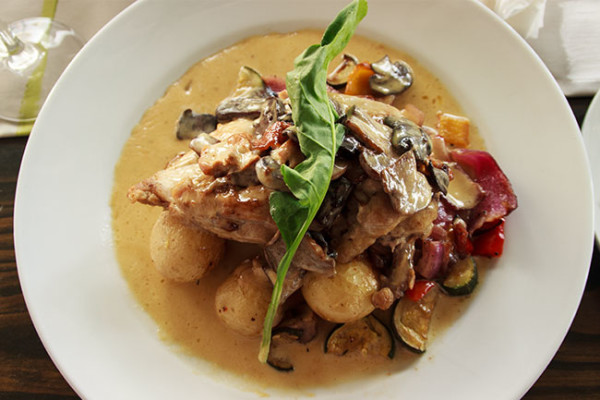 Chicken Supreme on a bed of sauteed new potatoes served with roast vegetables and brandy & mushroom jus