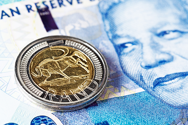 Five Rand coin rests on new Mandela South African banknote