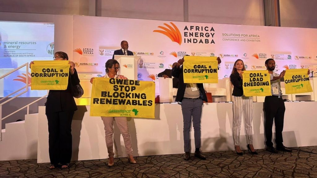 Activists hold a protest during Mantashe's African Energy Indaba address