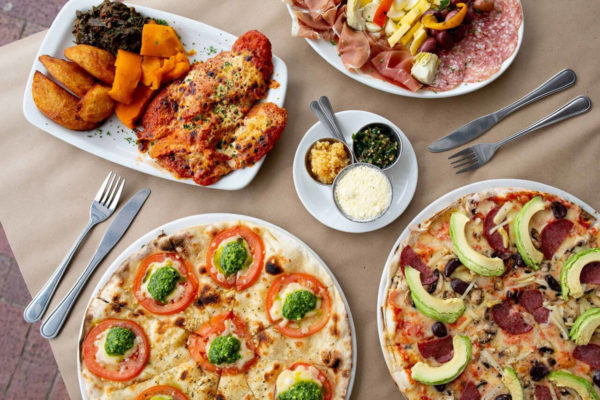 Assortment of Posticino Pizzas and Italian dishes, including a Prosciutto starter and sweet potato, from the renowned Best Pizza in Cape Town