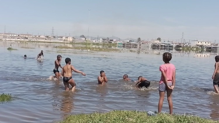 Children frolic in flood water as only pool in Brown’s Farm remains closed